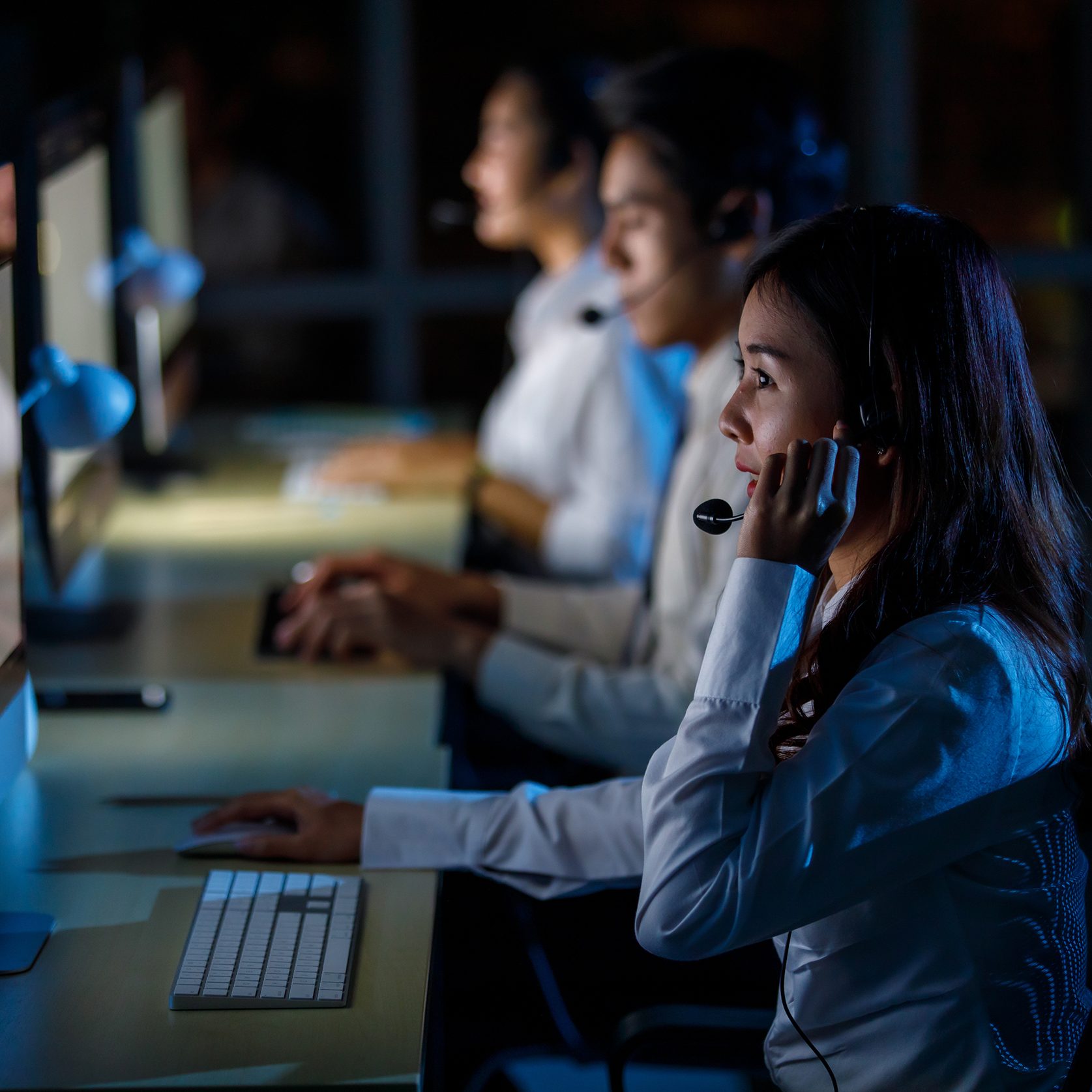 Emergency dispatch personnel answering calls in front of computers